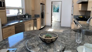 A modern kitchen with granite countertops, stainless steel appliances, and wooden cabinets.