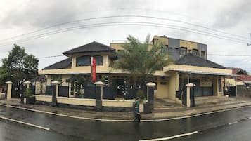 A two-story building with a tiled roof and a large entrance gate.