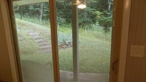 A sliding glass door with a view of a backyard.