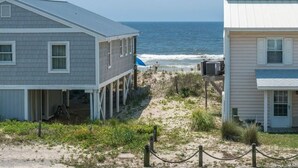 A beachfront property with two houses, a sandy path, and the ocean in the background. - Donovan's Out of the Blue  Great Value and Location! (Oak Island)