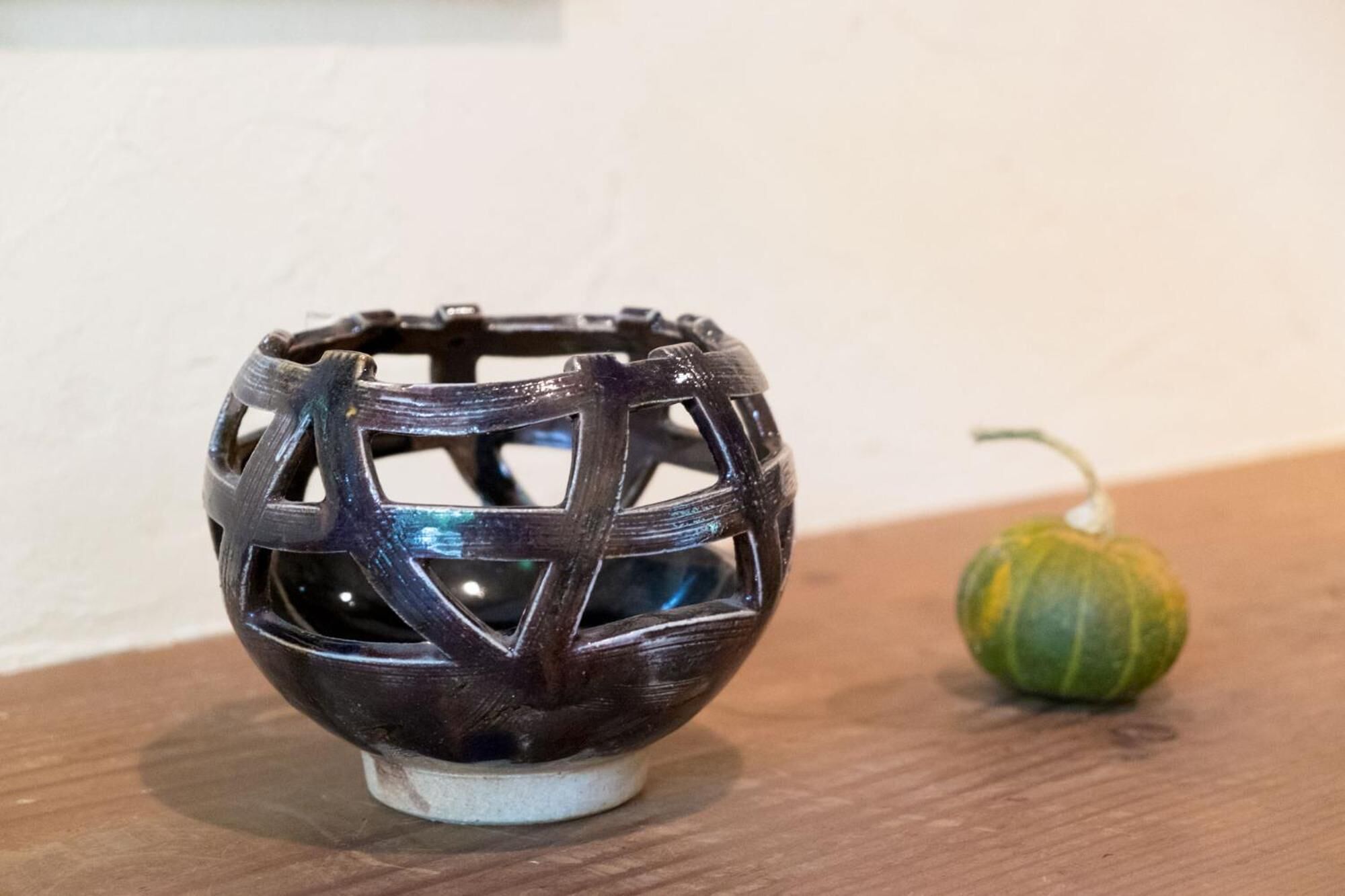 A dark wooden bowl with a geometric pattern on a wooden surface.