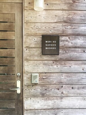 A wooden door with a metal handle and a sign that reads "MORI NO GARDEN MASHIKO". - Pension Morino Garden Mashiko (Mashiko)