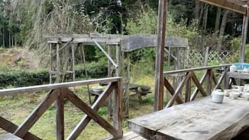 A wooden deck with picnic tables and a pergola structure.