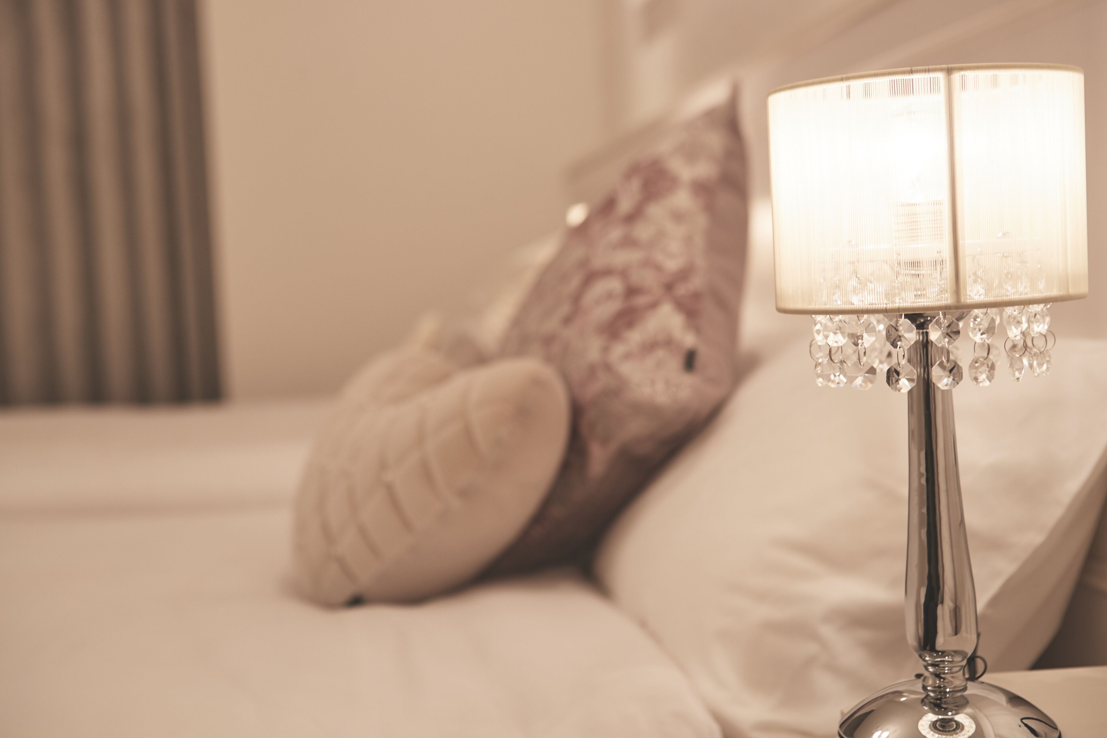 Un lit avec une lampe et des oreillers.