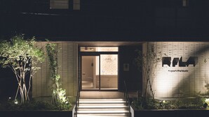 A building entrance at night with illuminated steps and a sign on the wall. - ReLA Higashimatsudo (Matsudo)