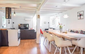A modern living room with a TV, sofa, and dining area with chairs. - 5 bedroom lovely home in Tving (Tving)