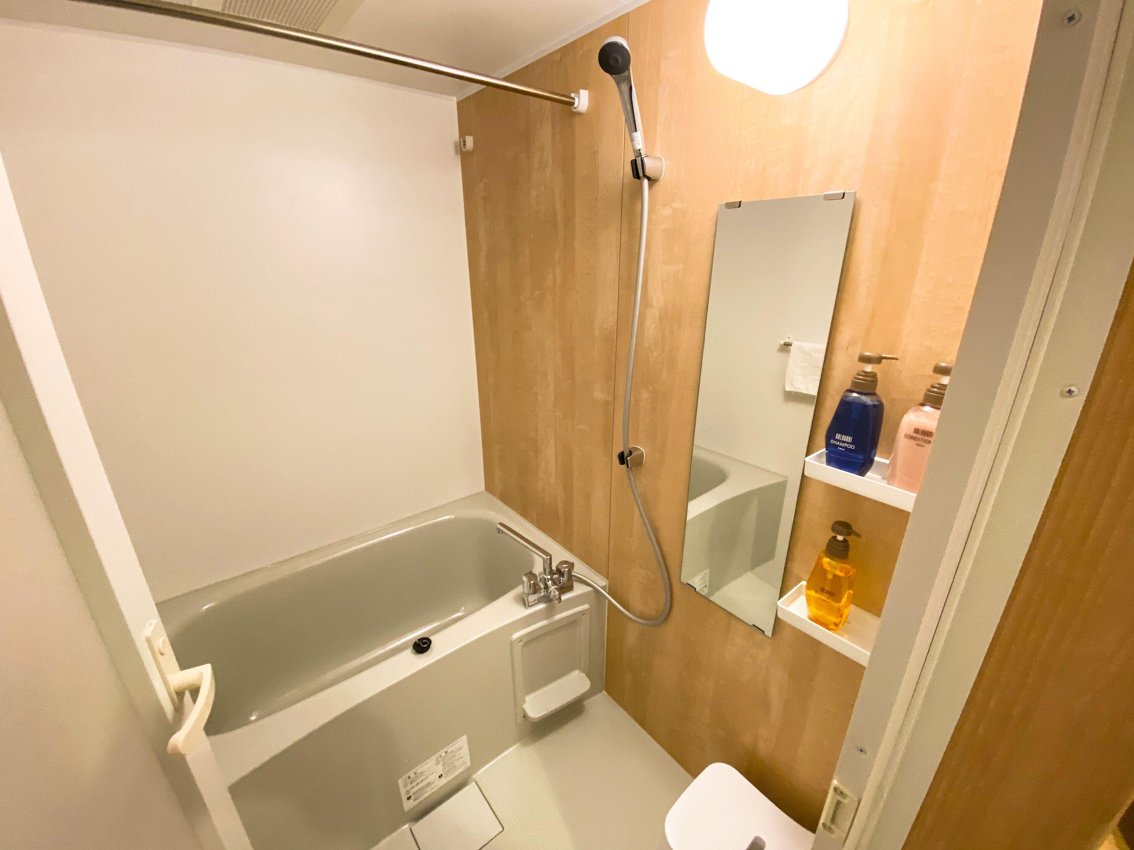 Ein modernes Badezimmer mit einer Badewanne, einer Dusche, einem Waschbecken und einem Spiegel.
