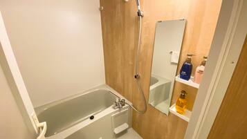 Ein modernes Badezimmer mit einer Badewanne, einer Dusche, einem Waschbecken und einem Spiegel.
