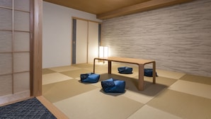 A tatami mat room with a low wooden table and cushions.