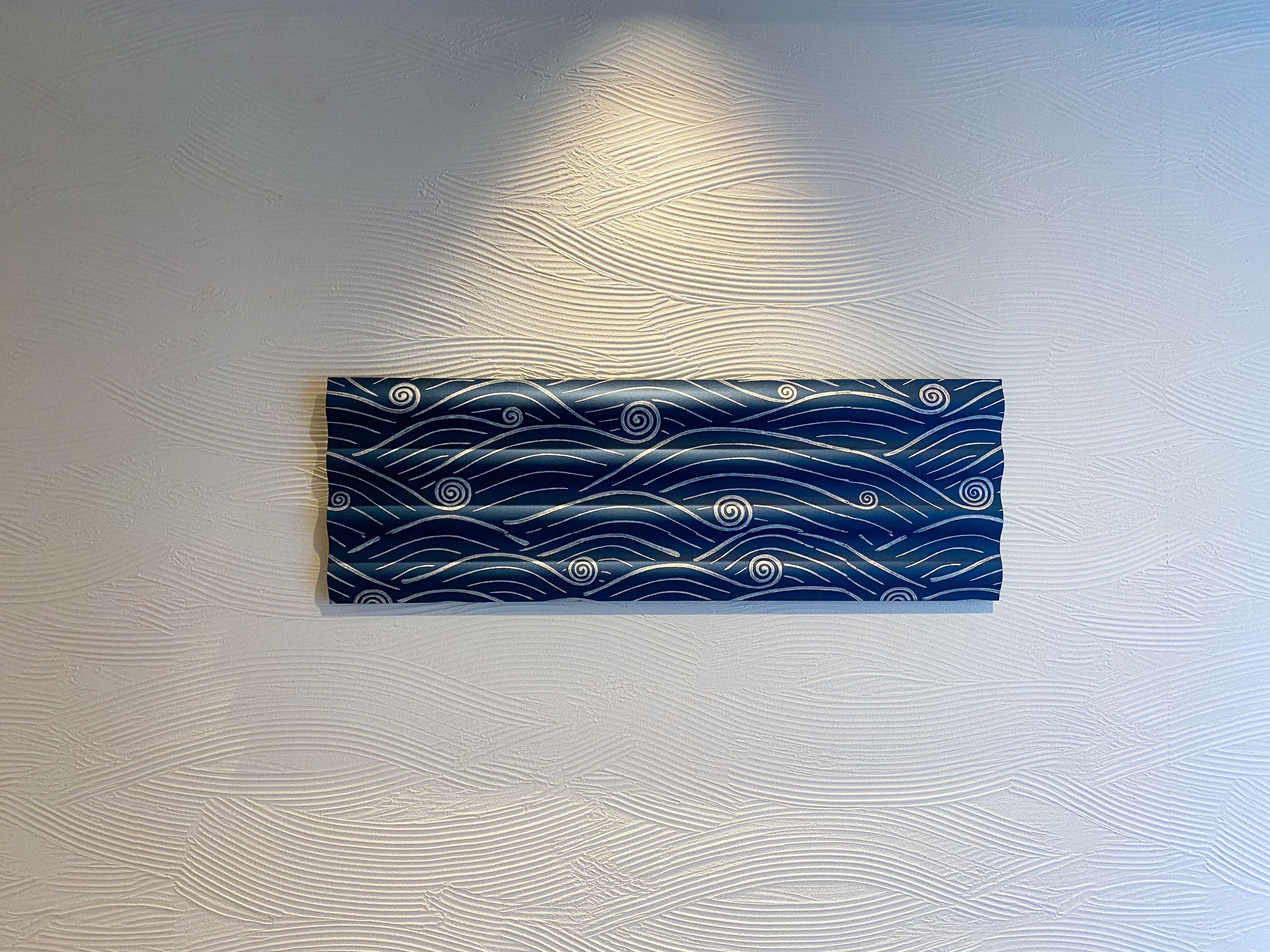 A wall with a textured pattern and a framed artwork.