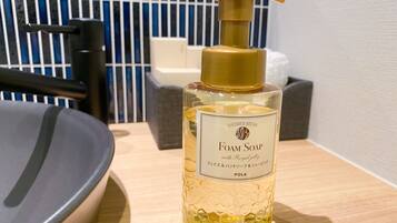 A bottle of foam soap with a pump dispenser on a wooden surface.