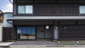 A modern building with a traditional entrance, a signboard, and a tiled roof.