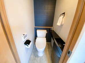 A compact bathroom with a toilet, a towel rack, and a paper towel dispenser. - Rinn Niomon (Kyoto)