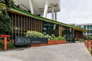 A modern building with a sign reading "ARENA APARTMENTS".
