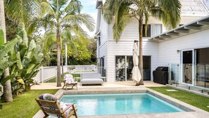 Relax by the pool surrounded by lush greenery and enjoy al fresco dining with a barbecue grill nearby.