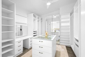 A spacious walk-in closet with multiple storage options including shelves, drawers, and hanging space.