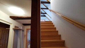 Una escalera de madera con barandilla que lleva a una plataforma.