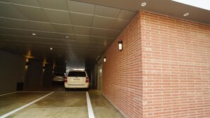 A parking garage with a white SUV parked in a space. - Hotel Mare (Busan)