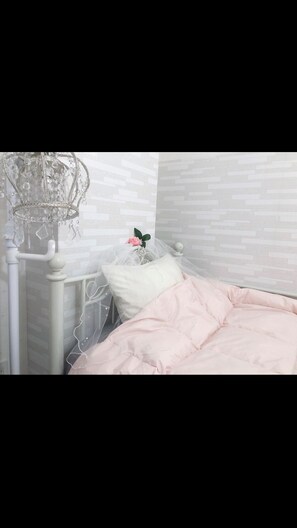 A bedroom with a bed, a nightstand, and a decorative chandelier. - Sapporo Princess Hotel - Hostel (Sapporo)