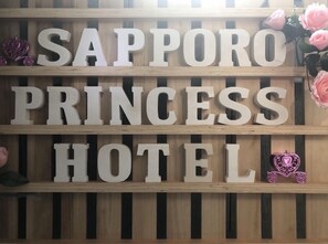 A wooden sign with the words "Sapporo Princess Hotel" in large letters. - Sapporo Princess Hotel - Hostel (Sapporo)