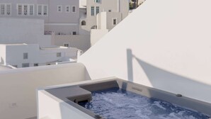 A modern rooftop with a hot tub, white buildings, and a clear sky. - Thallos Cave House and Apartments (Santorini)