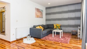 A modern living room with a grey sofa, a white side table, and a pink rug. - Stunning home in Bilice (Bilice)