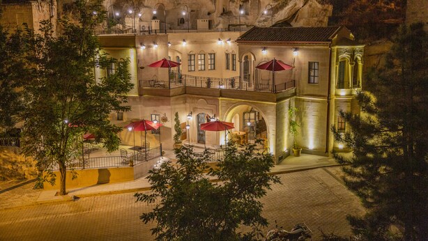 A hotel with a courtyard, outdoor seating, and a view of the surrounding rocky landscape. - Sinasos Star Hotel Cappadocia (Ürgüp)