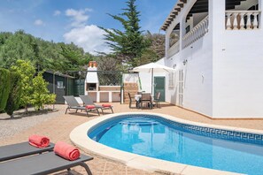 Een buitenzwembad en ligstoelen