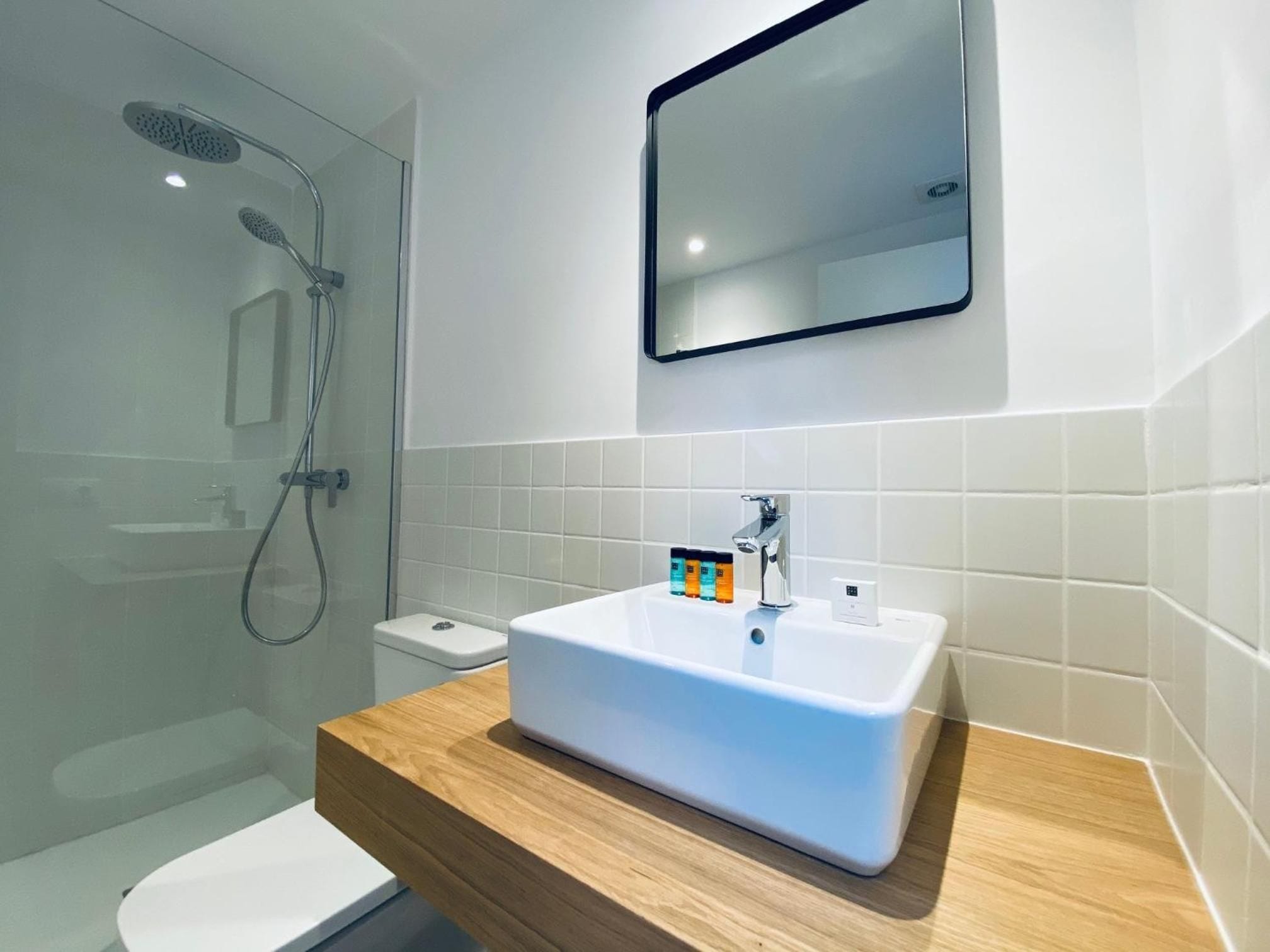 A modern bathroom with a shower, toilet, and sink.