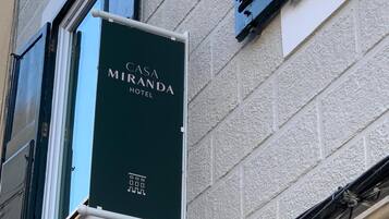 A sign for 'CASA MIRANDA HOTEL' with a building facade in the background.