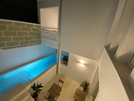 Um espaço moderno ao ar livre com piscina, área de estar e um pequeno jardim.