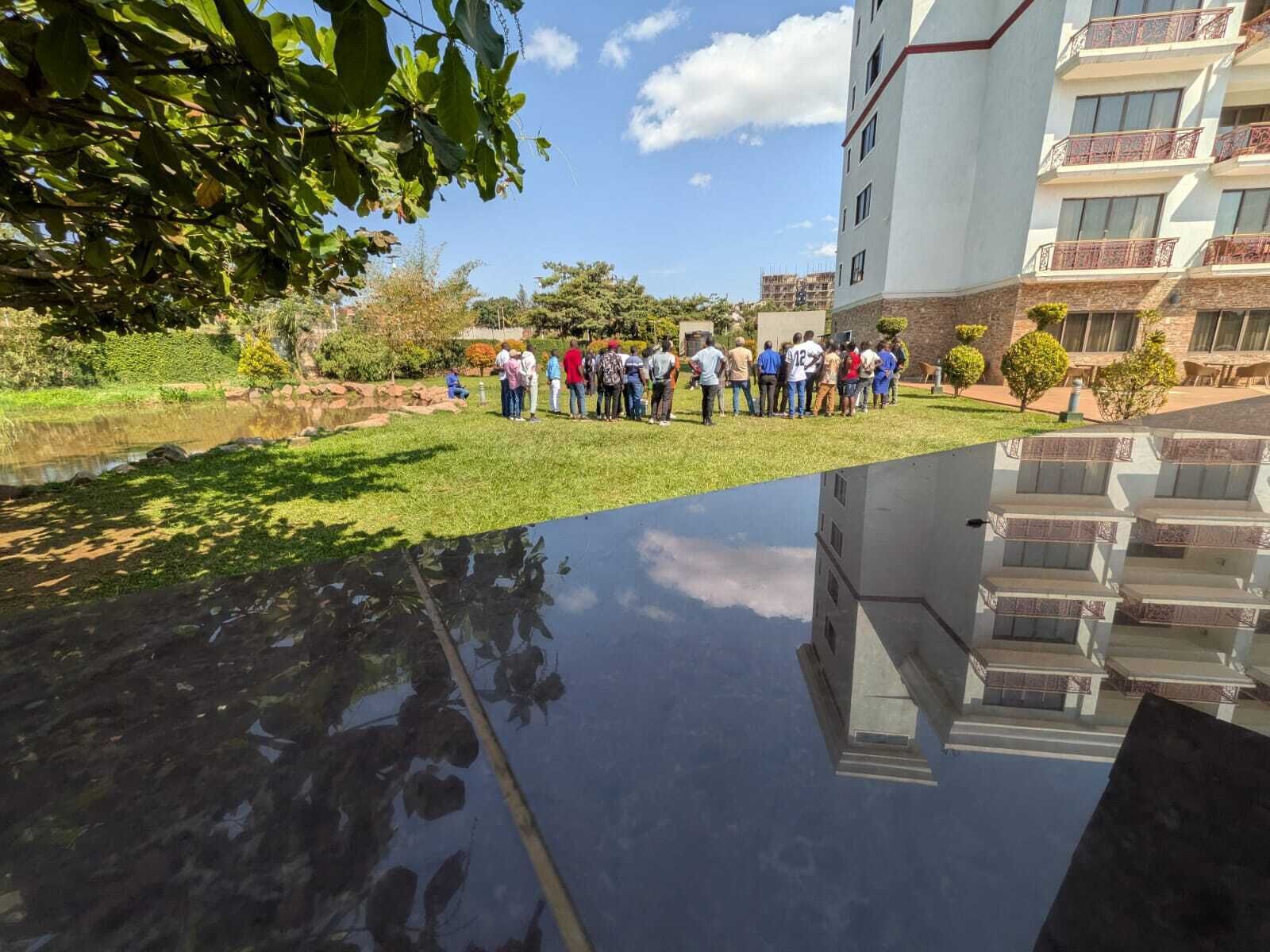 Um grupo de pessoas está em um pátio com um edifício ao fundo.