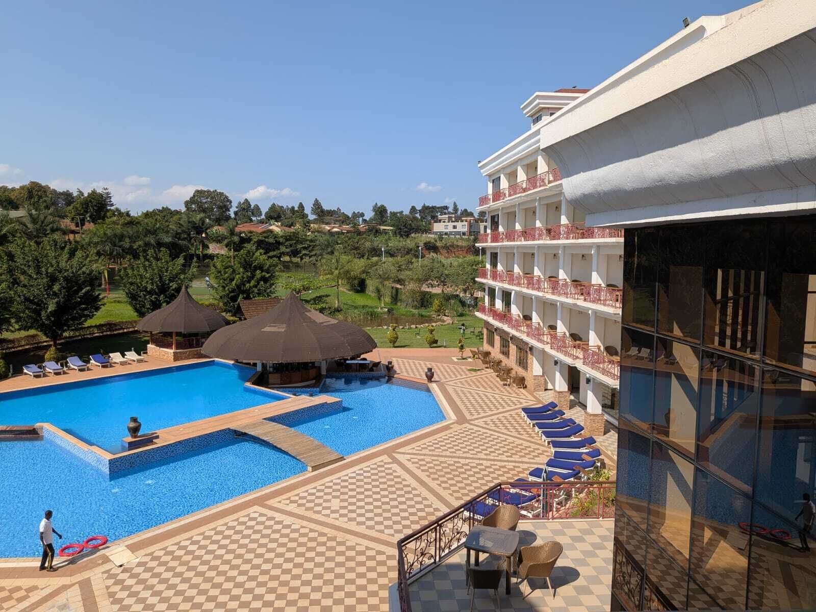 Ein Hotel mit Schwimmbad, Liegestühlen und Blick auf die umliegende Landschaft.