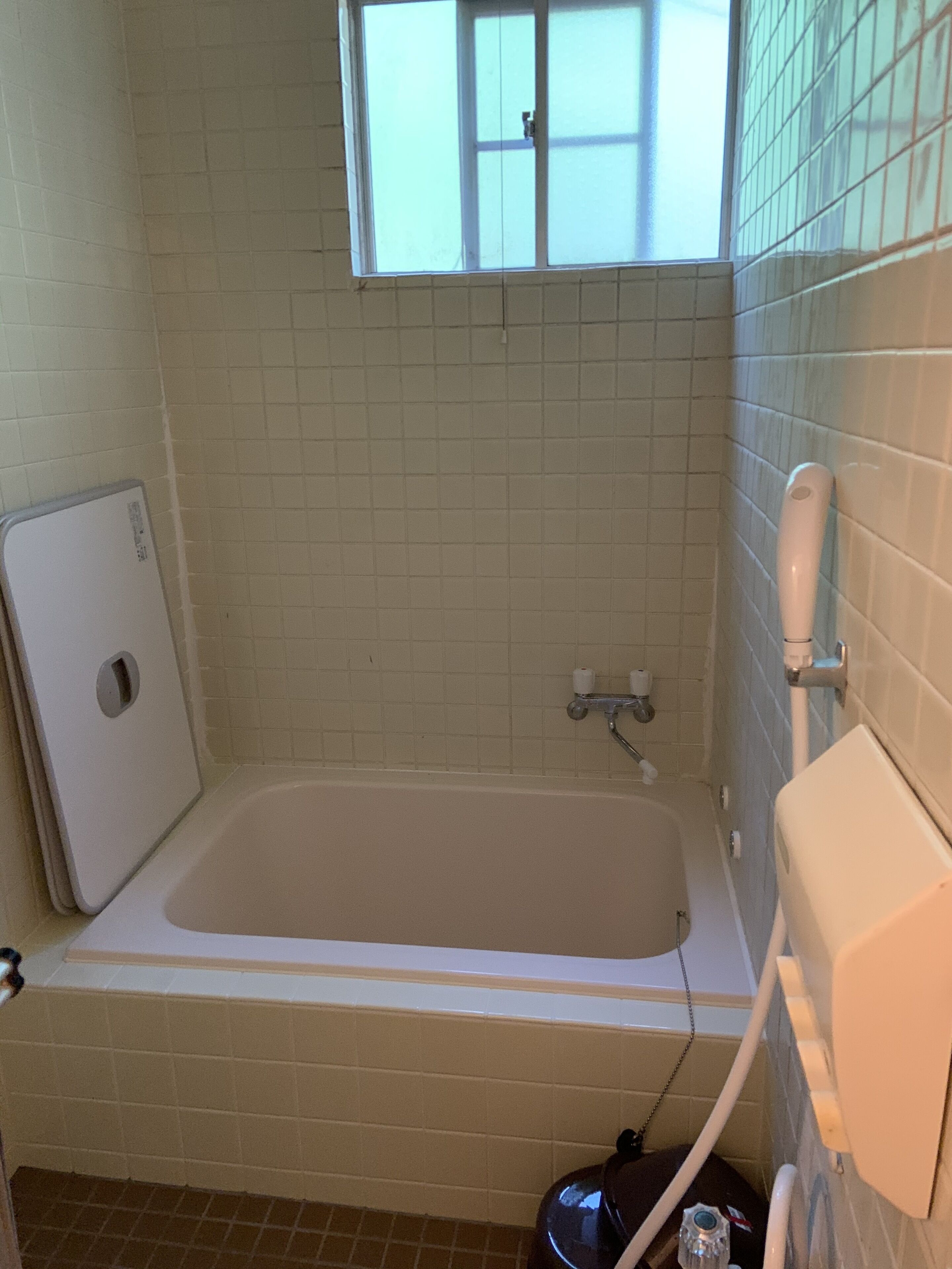 Un baño con bañera, ventana y retrete.