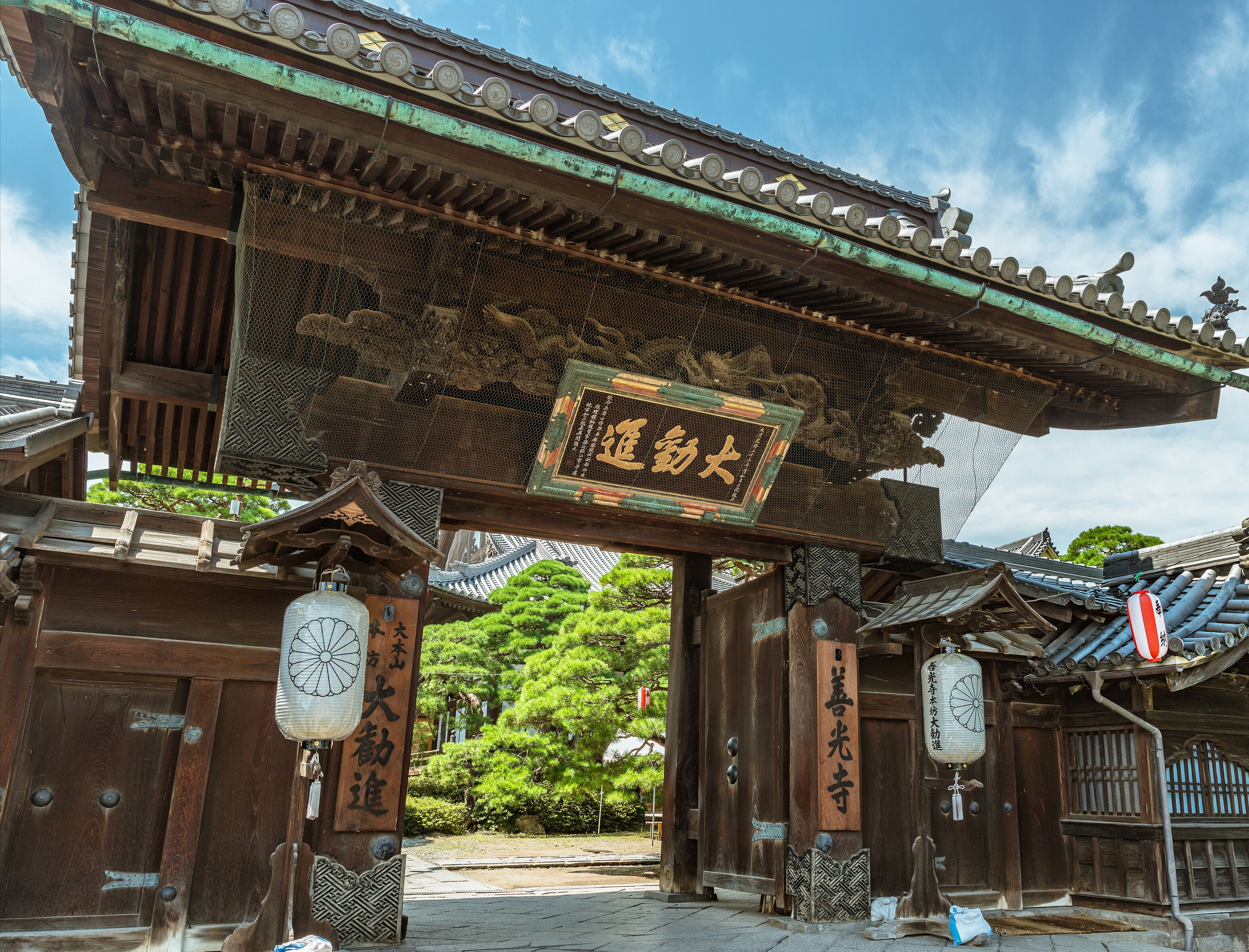 Un torii tradicional japonés con arquitectura de madera y una placa.