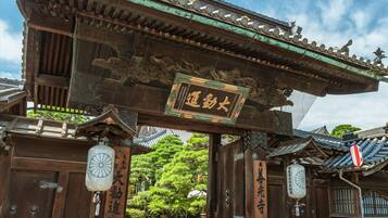 A traditional Japanese gate with wooden architecture and a signboard.