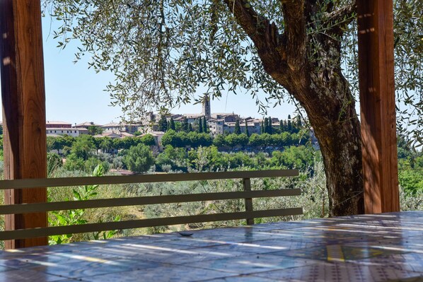 A table with a map, a wooden railing, and a view of a town with buildings and trees. - House with private pool, air conditioning and stunning views!!! (Montecchio)