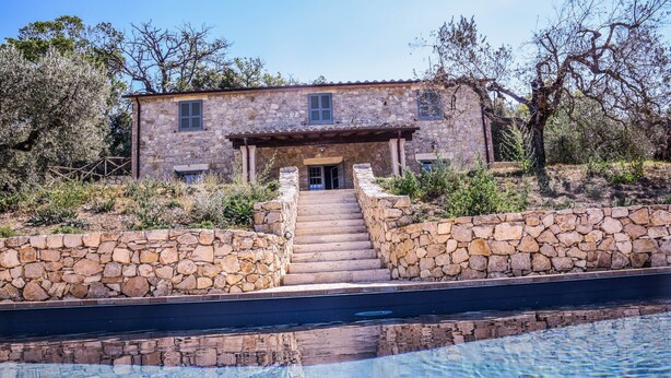 A stone house with a pool in front, surrounded by trees and a stone wall. - House with private pool, air conditioning and stunning views!!! (Montecchio)