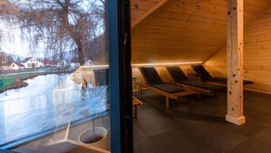 A sauna room with wooden benches and a glass wall overlooking a snowy landscape. - Kozjanski dvor (Kozje)