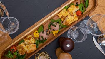 Una bandeja de madera con comida y bebidas sobre una mesa.