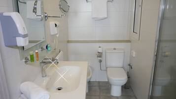 A bathroom with a sink, toilet, and shower.