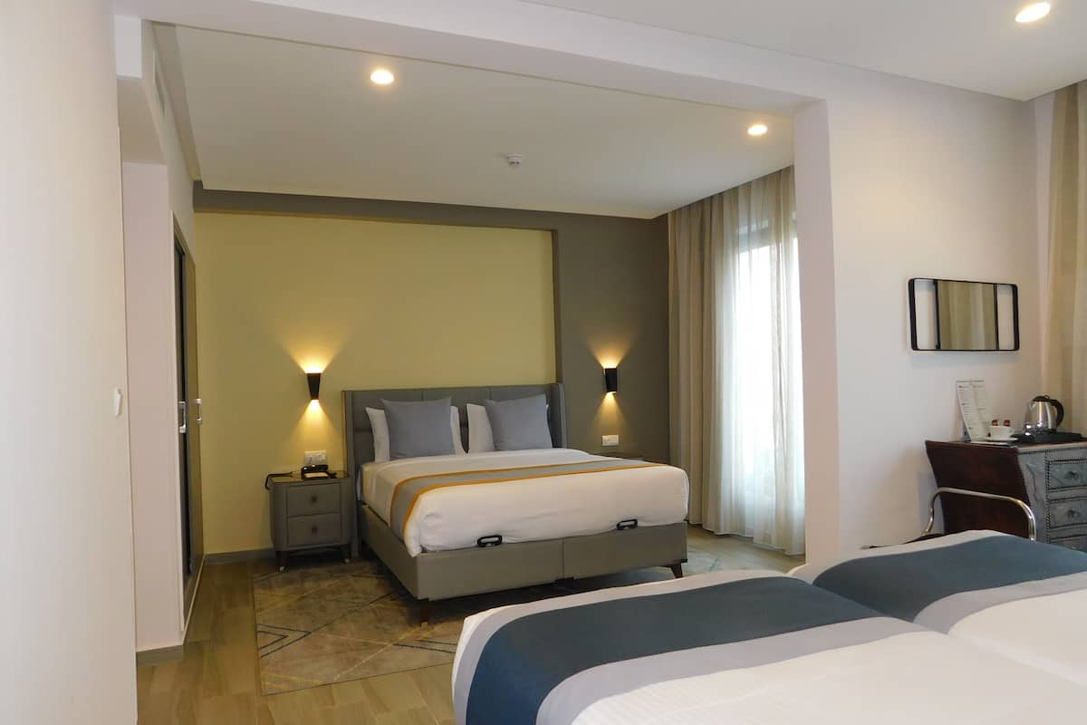 Une chambre d’hôtel comprenant un lit, des tables de chevet, un bureau et une chaise.