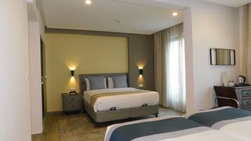 A hotel room with a bed, bedside tables, a desk, and a chair.