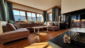 Un salón amplio con un sofá grande, una mesa de centro y una chimenea.