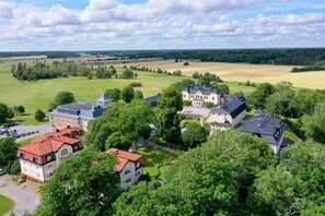 A large estate with multiple buildings, surrounded by lush greenery and open fields. - Johannesbergs Slott (Rimbo)