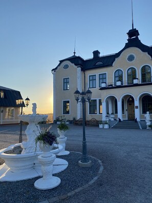 A large, historic building with a symmetrical facade, multiple windows, and a prominent entrance with steps leading up to a door. - Johannesbergs Slott (Rimbo)