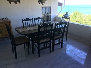 Enjoy meals in this dining area with a round table and six comfortable chairs, set against a stunning ocean view.