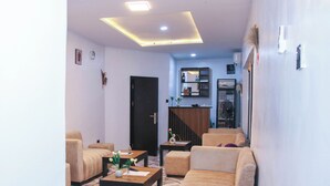 A modern living room with a sofa, two armchairs, a coffee table, and a patterned floor. - Xela Hotels and Resorts (Ife)