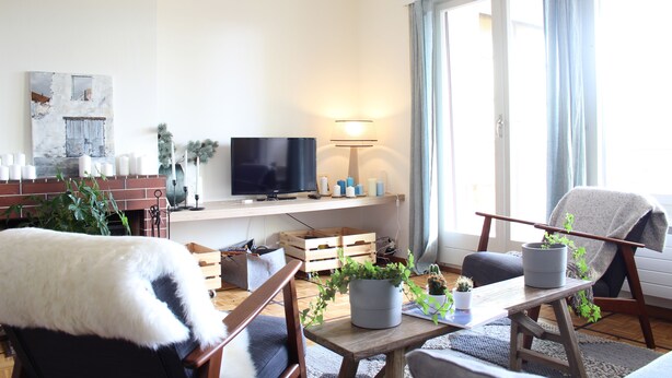 A living room with a television, wooden furniture, and potted plants. - Central & Cozy - Rainbow A (Lens)