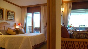 A bedroom with a bed, a nightstand, a lamp, and a window with curtains. - Charming & Intimate - Estoril (Crans-Montana)